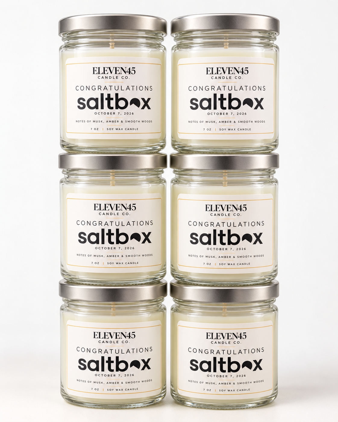 Six stacked jar candles with custom Congratulations Saltbox labels dated October 7, 2026